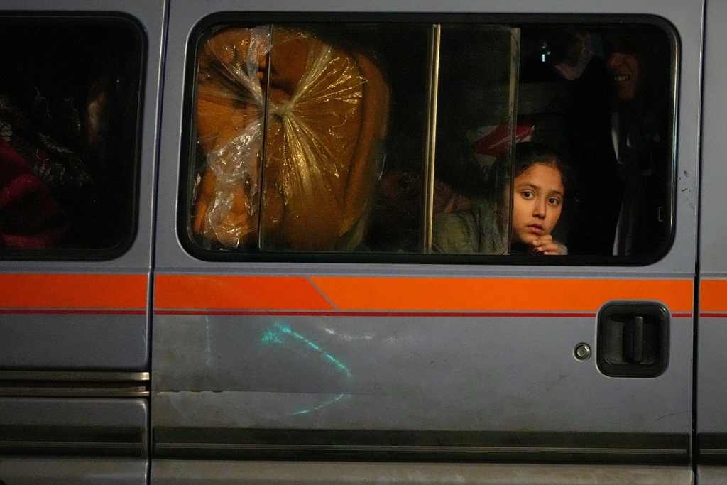 A girl sits in a van as displaced families fleeing Israeli strikes in southern Lebanon arrive in the southern port city of Sidon, early Monday, March 2, 2026. (AP Photo/Mohammed Zaatari)