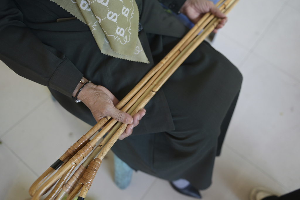 An official holds rattan sticks which will be used to cane people who violate Shariah law including two men convicted of hugging and kissing, which the court ruled can lead to banned sexual relations, in Banda Aceh, Aceh province, Indonesia, Tuesday, Aug. 26, 2025. (AP Photo/ Reza Saifullah)