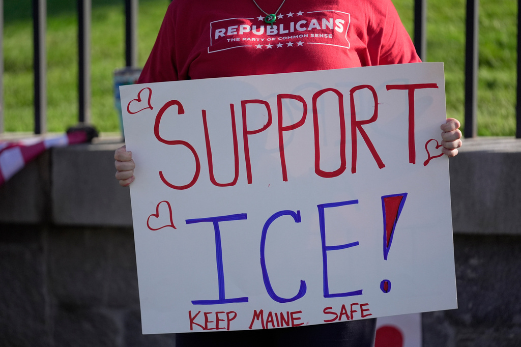 FILE - A woman holds a sign in support in support of U.S. Immigration and Customs Enforcement, outside the State House in Augusta, Maine, July 15, 2026. (AP Photo/Robert F. Bukaty, File)