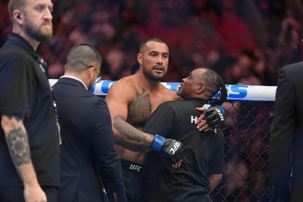 Carlos Ulberg, center, of New Zealand, reacts after defeating Jiri Prochazka, of Czechia, by TKO to win their light heavyweight title bout at a UFC 327 mixed martial arts event, Saturday, April 11, 2026, in Miami. (AP Photo/Rebecca Blackwell)