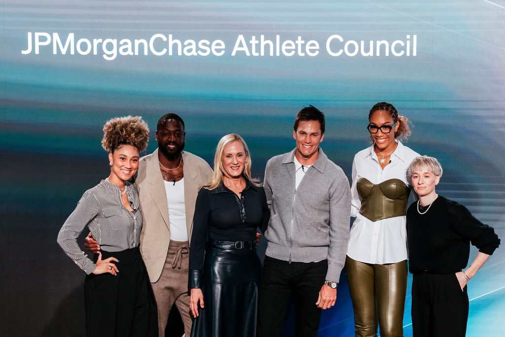 Kristin Lemkau, CEO, J.P. Morgan Wealth Management, center left, poses for a picture with, from left, Ally Love, Peloton Instructor + VP, Instructor Strategy & Development, Dwyane Wade, former NBA basketball player, Tom Brady, former NFL football player, A'ja Wilson WNBA basketblal player, and Meg Rapinoe, former women's soccer player, during a Pro Athlete event at JPMorganChase headquarters in New York, Wednesday, March 18, 2026. (AP Photo/Eduardo Munoz Alvarez)