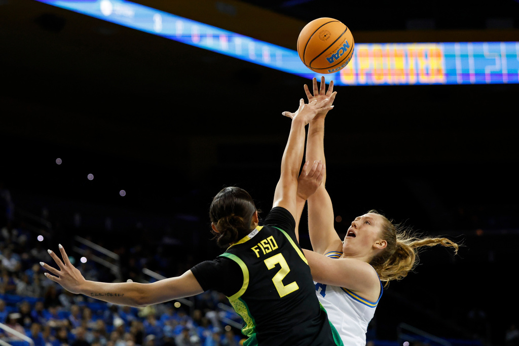 UCLA guard Gianna Kneepkens, right, drives to the basket while pressured by Oregon guard Katie Fiso (2) during the first half of an NCAA college basketball game Sunday, Dec. 7, 2025, in Los Angeles. (AP Photo/Caroline Brehman)