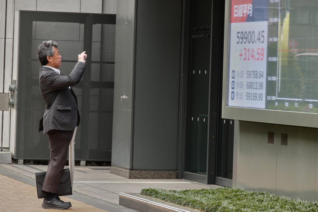 A person takes a photo of an electronic stock board showing Japan's Nikkei index outside a securities firm Thursday, April 23, 2026, in Tokyo. (AP Photo/Eugene Hoshiko)