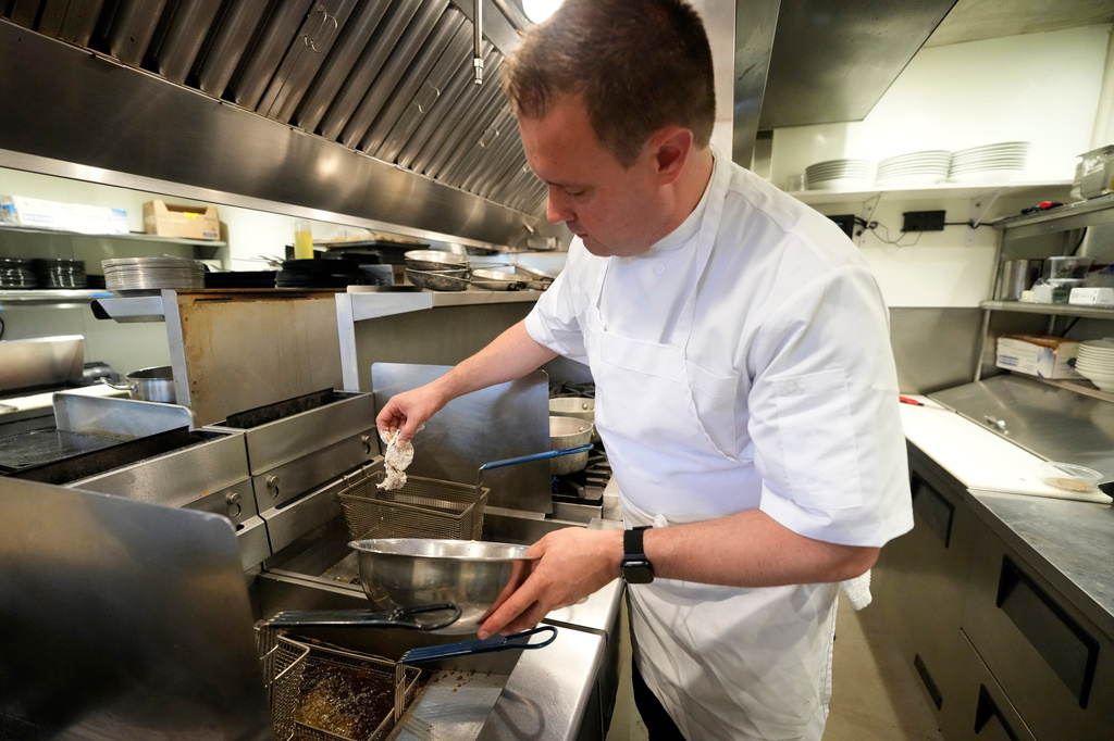 Executive chef Benjamin Hasty drops a breaded green crab into a fryer at Signal restaurant Tuesday, June 16, 2026, in Kennebunk, Maine. (AP Photo/Robert F. Bukaty)