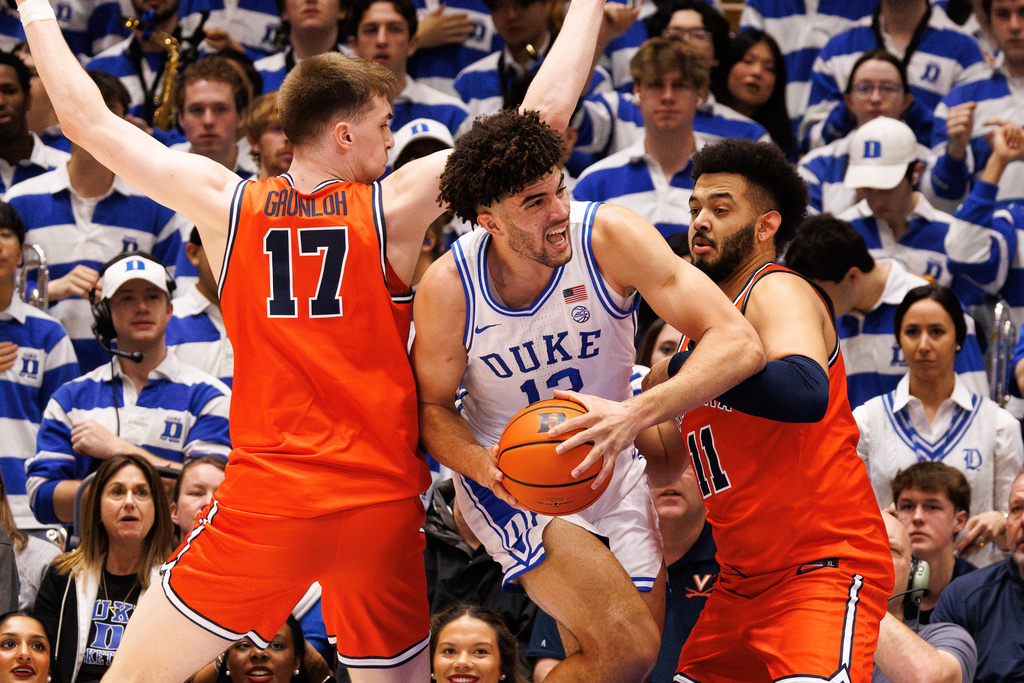 Duke's Cameron Boozer (12) handles the ball between Virginia's Johann Grünloh (17) and Devin Tillis (11) during the first half of an NCAA college basketball game in Durham, N.C., Saturday, Feb. 28, 2026. (AP Photo/Ben McKeown)