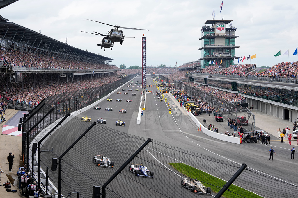 FILE - Helicopters fly over the field on the parade lap before the Indianapolis 500 auto race in Indianapolis, May 24, 2026. (AP Photo/Michael Conroy, File)