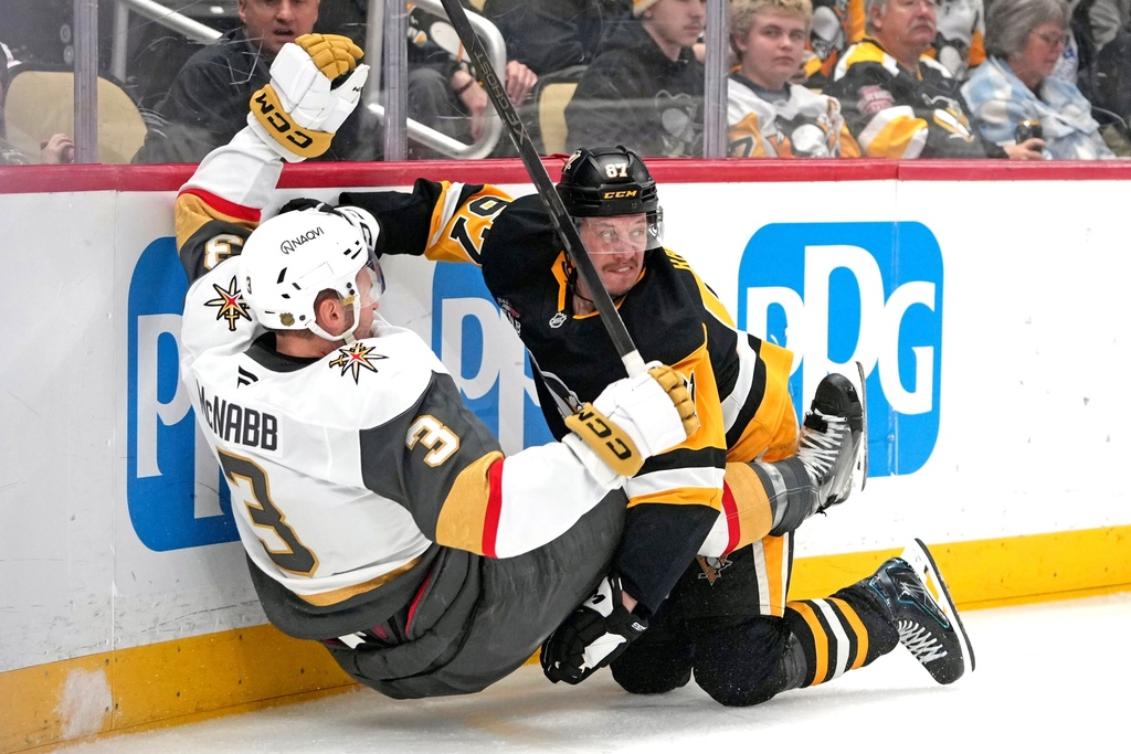 Pittsburgh Penguins' Rickard Rakell (67) collides with Vegas Golden Knights' Brayden McNabb (3) during the second period of an NHL hockey game in Pittsburgh, Sunday, March 1, 2026. (AP Photo/Gene J. Puskar)