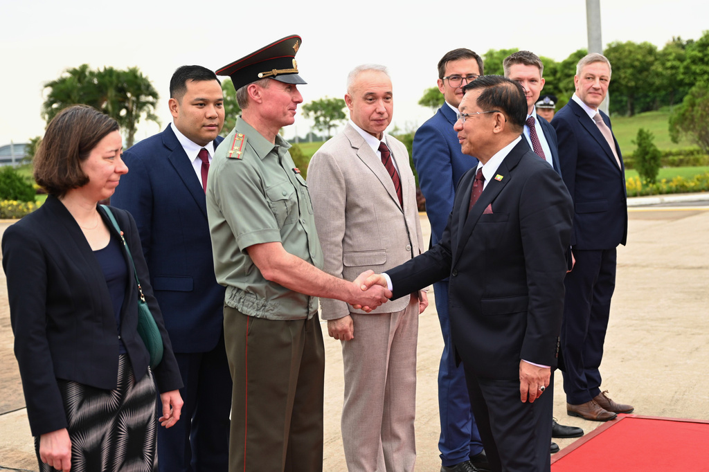 In this photo released by Myanmar President Office, Myanmar President Min Aung Hlaing, right, shakes hands with a Russian diplomat upon his departure to Russia, at the Naypyitaw international airport Monday, Aug. 17, 2026, in Naypyitaw, Myanmar. (Myanmar President Office via AP)