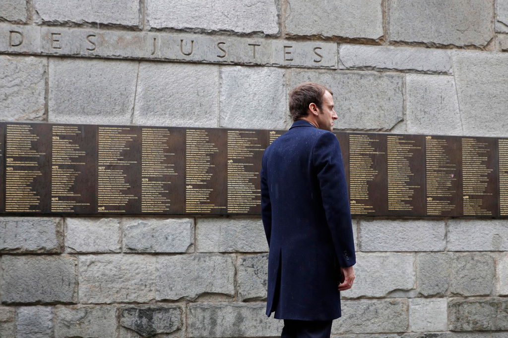 FILE - Independent centrist presidential candidate Emmanuel Macron stands at the "Mur des Justes" at the Shoah Museum, a wall on which 2,693 names of people who protected or saved Jews during World War II are engraved in Paris, April 30, 2017. (Philippe Wojazer/Pool Photo via AP, File)