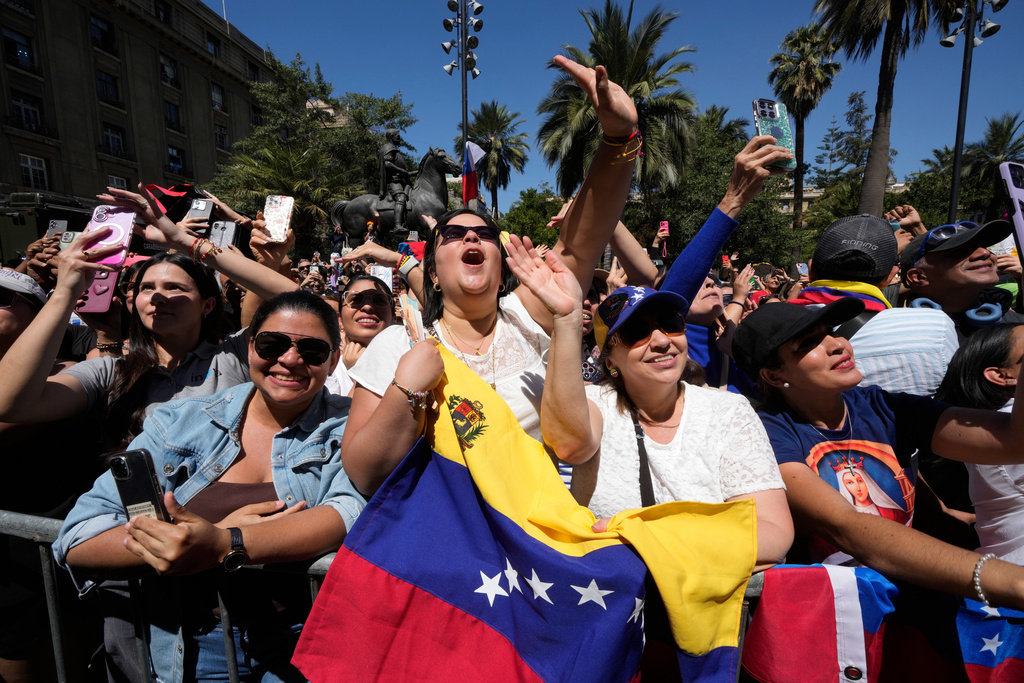 Supporters of Venezuela's opposition leader Maria Corina Machado gather outside the municipal palace during a ceremony in which she receives the keys to the city in Santiago, Chile, Thursday, March 12, 2026. (AP Photo/Gustavo Garello)