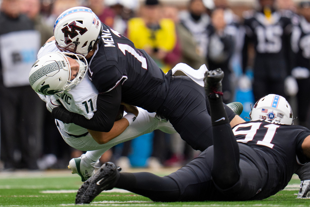 Michigan State quarterback Alessio Milivojevic (11) is sacked by Minnesota defensive lineman Karter Menz (11) during the first half of an NCAA college football game Saturday, Nov. 1, 2025, in Minneapolis, Minn. (Alex Kormann/Star Tribune via AP)