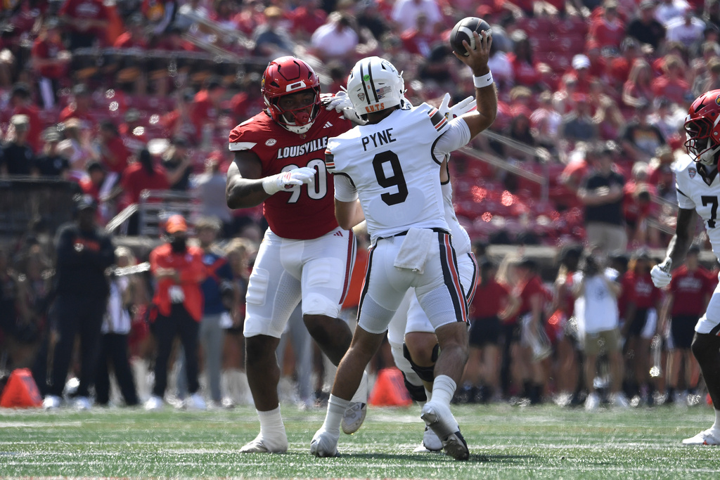 Louisville defensive lineman Rene Konga (90) puts pressure on Bowling Green quarterback Drew Pyne (9) during the first half of an NCAA college football game in Louisville, Ky., Saturday, Sept. 20, 2025. (AP Photo/Timothy D. Easley)