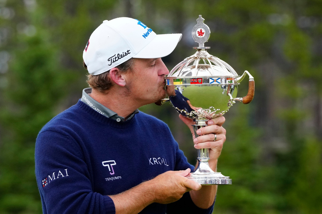 Bud Cauley, of the United States, kisses the trophy after winning the Canadian Open golf tournament in Caledon, Ontario, Sunday June 14, 2026. (Frank Gunn/The Canadian Press via AP)