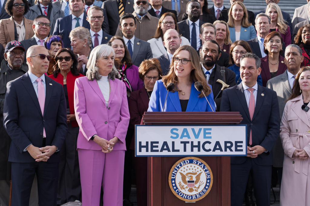 Rep. Sarah McBride, D-Del., center, joins House Minority Leader Hakeem Jeffries, D-N.Y., far left, and fellow Democrats as they advocate for improving the health care funding system, on the steps of the House before votes to end the government shutdown, at the Capitol in Washington, Wednesday, Nov. 12, 2025. (AP Photo/J. Scott Applewhite)
