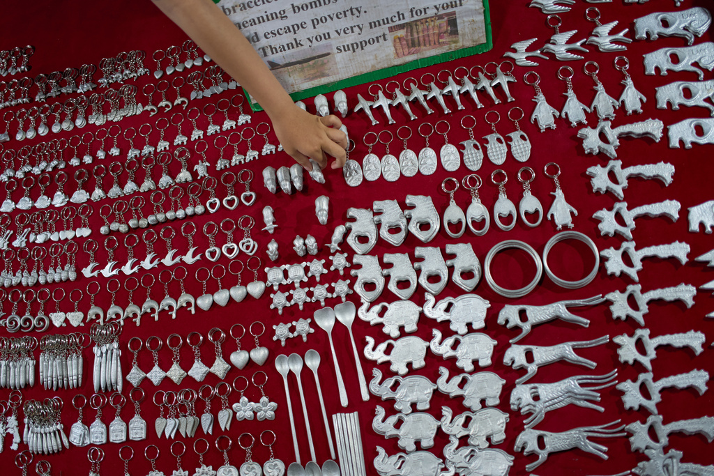 A vendor arranges metal souvenirs made from recycled fragments of unexploded ordnance left from the Vietnam War at a night market in Luang Prabang, Laos, Monday, Nov. 3, 2025. (AP Photo/Eugene Hoshiko)