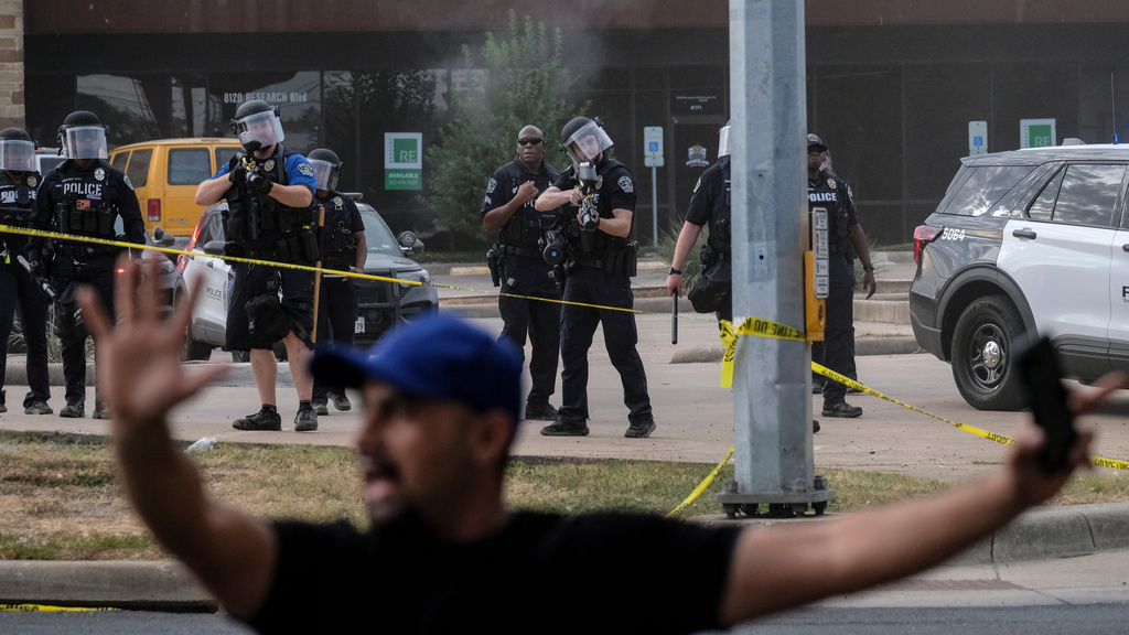 Authorities deploy non-lethan weapons near a demonstration where a man was shot in his vehicle by an ICE officer, Sunday, Sept. 20, 2026, in Austin, Texas. (AP Photo/Joel Angel Juarez)