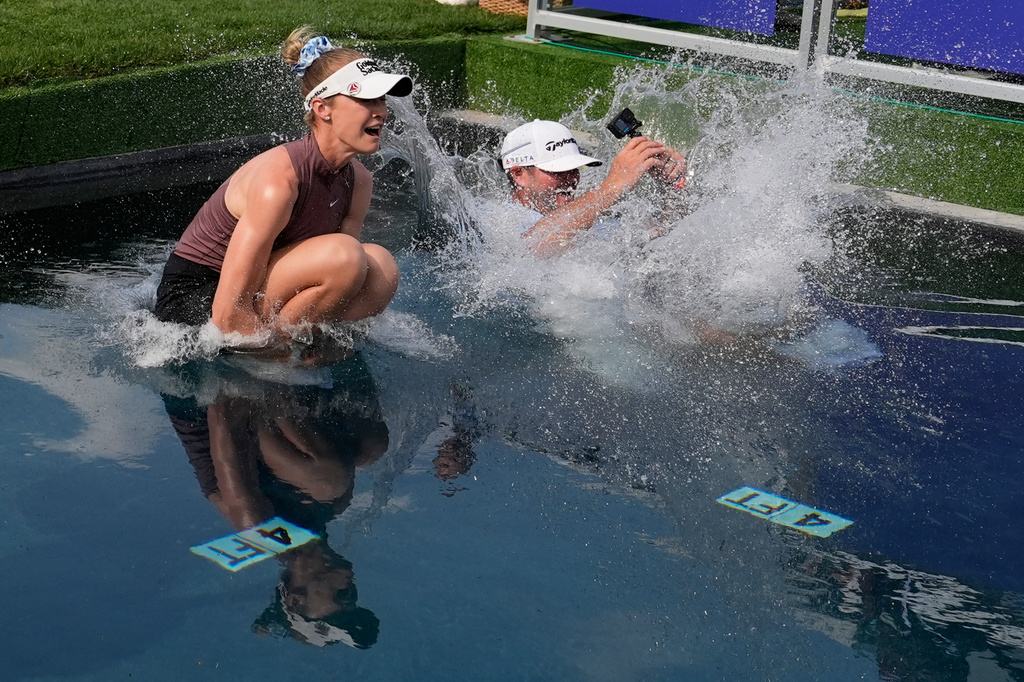 Nelly Korda jumps in the water with her caddie after winning the Chevron Championship LPGA golf tournament Sunday, April 26, 2026, in Houston. (AP Photo/Ashley Landis)