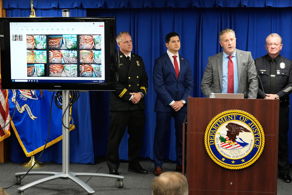 Special Agent in Charge Kenny Cooper, of the Bureau of Alcohol, Tobacco, Firearms and Explosives, Los Angeles Field Division, second from right, speaks between Acting U.S. Attorney Bill Essayli, second from left, and Los Angeles Police Chief Jim McDonnell, right, during a news conference announcing an arrest made in the Palisades Fire, Wednesday, Oct. 8, 2025, in Los Angeles. (AP Photo/Damian Dovarganes)