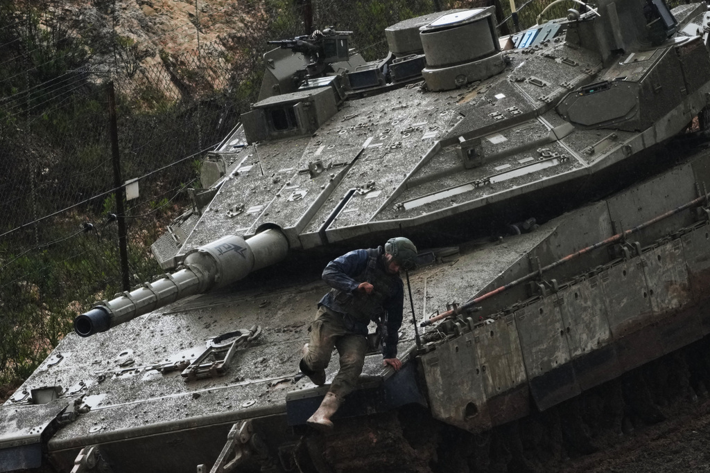 An Israeli soldier jumps from a tank in northern Israel near the border with Lebanon, Saturday, March 21, 2026. (AP Photo/Ariel Schalit)