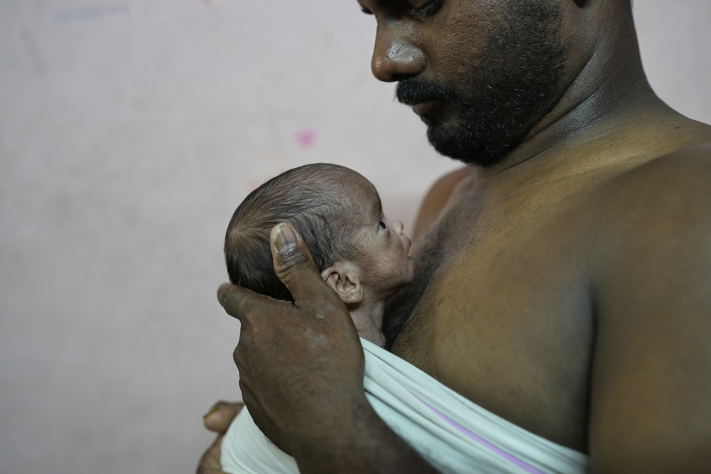 Sikander Chaudhary gives the Kangaroo Mother Care (KMC), a method of holding a baby skin-to-skin on the caregiver's chest, to promote bonding and well-being, to his newborn son in his house in Gurugram, a satellite city of New Delhi, India, Friday, Aug. 8, 2025. (AP Photo/Manish Swarup)