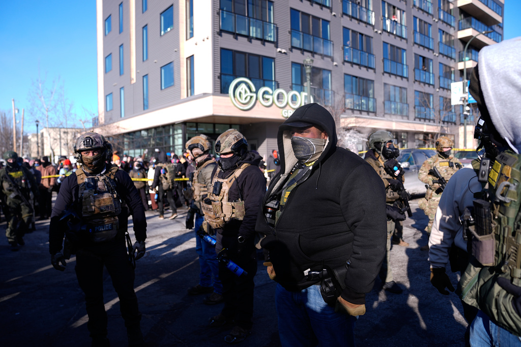 Federal agents stand near the site of a shooting Saturday, Jan. 24, 2026, in Minneapolis. (AP Photo/Abbie Parr)