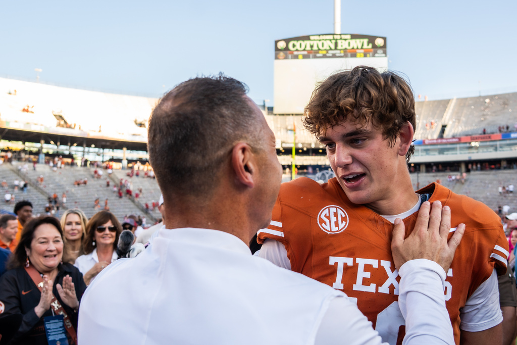 Texas Longhorns quarterback Arch Manning (16) embraces Texas Longhorns head coach Steve Sarkisian after beating Oklahoma in an NCAA college football game at the Cotton Bowl in Dallas, Saturday, Oct. 11, 2025. (Sara Diggins/Austin American-Statesman via AP)