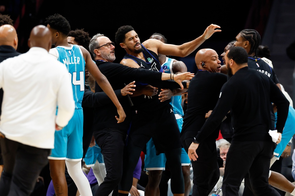 Charlotte Hornets and Detroit Pistons coaches and security try to break up a fight during the second half of an NBA basketball game in Charlotte, N.C., Monday, Feb. 9, 2026. (AP Photo/Nell Redmond)