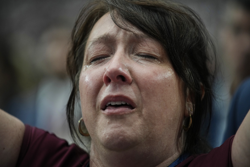 A woman is overcome with emotion while watching a Charlie Kirk tribute video during a memorial for the conservative activist Sunday, Sept. 21, 2025, at State Farm Stadium in Glendale, Ariz. (AP Photo/John Locher)