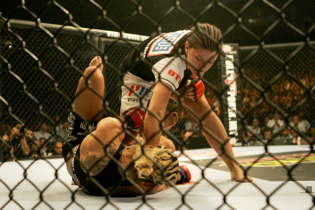 FILE - Gina Carano, top, punches Cris "Cyborg" Santos, of Brazil, in a Strikeforce mixed martial arts Female Middleweight Championship match, Aug. 15, 2009, in San Jose, Calif. (AP Photo/Jeff Chiu, File)