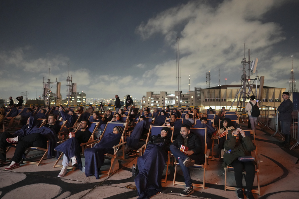 People watch 'A Star Is Born' at an open-air movie theater on the rooftop of a shopping mall on Paulista Avenue in Sao Paulo, Saturday, Aug. 30, 2025. (AP Photo/Andre Penner)