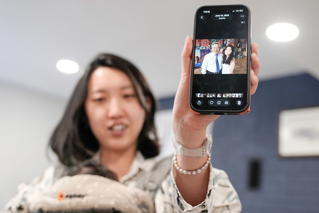 Grace Jin Drexel shows the old photos of her father after an interview with The Associated Press in Maryland, Wednesday, July 22, 2026 . (AP Photo/Mariam Zuhaib)