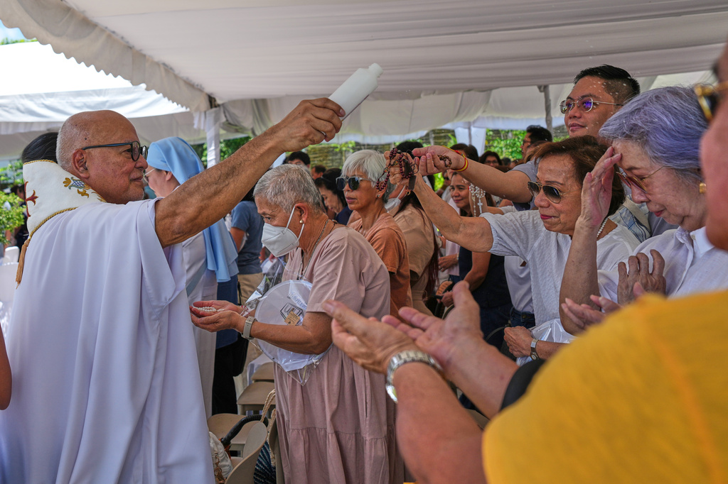 Catholic priest Father Dennis Paez sprinkles holy water to pilgrims during their visit at the Ephesus House, a replica of the House of the Virgin Mary in Ephesus, Turkey, at Alfonso town, Cavite province, Philippines on July 16, 2026. (AP Photo/Aaron Favila)