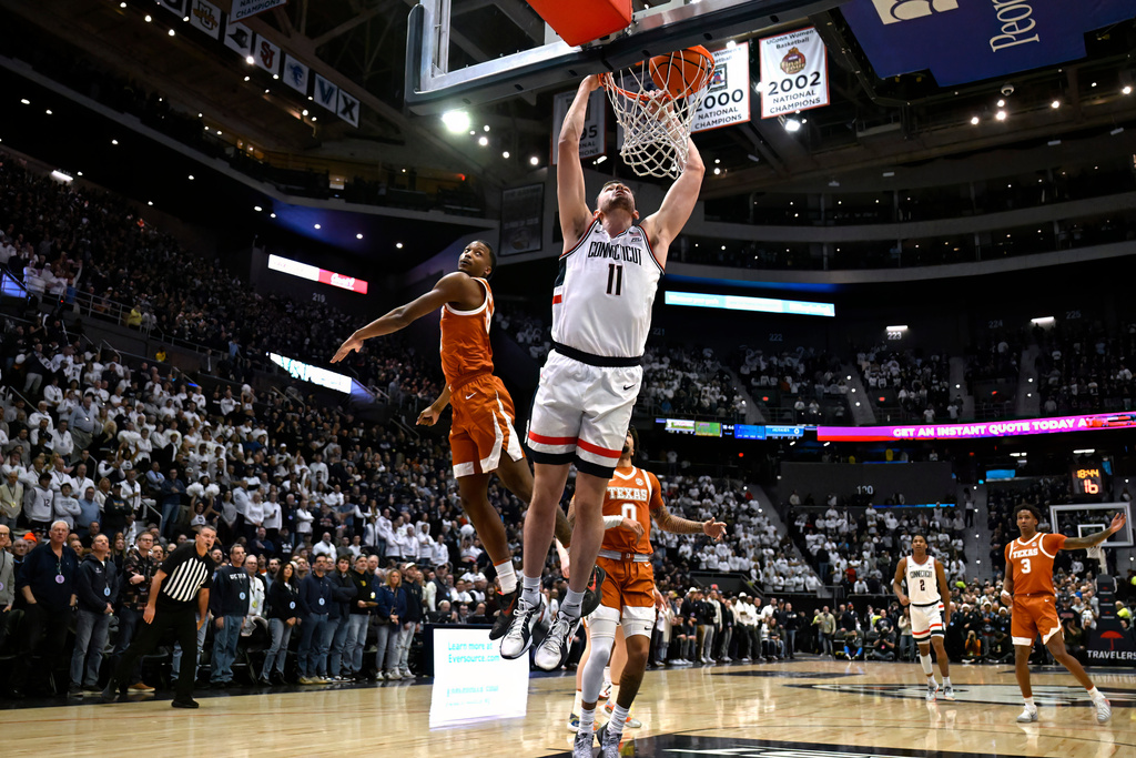 UConn forward Alex Karaban (11) dunks in the first half of an NCAA college basketball game against Texas, Friday, Dec. 12, 2025, in Hartford, Conn. (AP Photo/Jessica Hill)