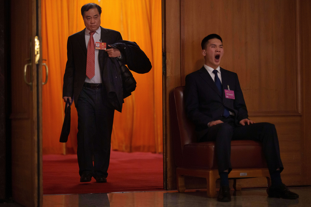 A soldier dressed as usher, sitting right, guards the opening session of the National People's Congress (NPC) at the Great Hall of the People in Beijing, China, Thursday, March 5, 2026. (AP Photo/Vincent Thian)