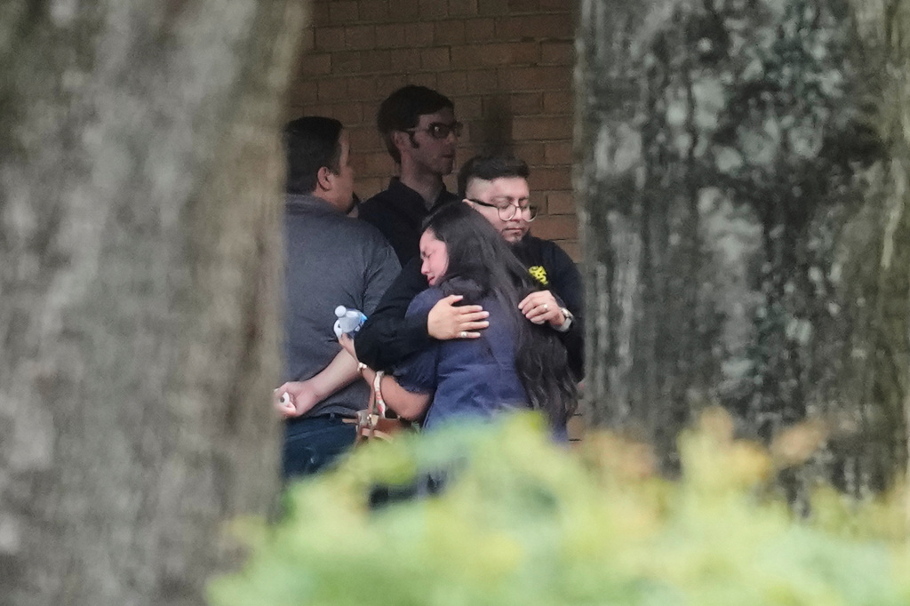 People hug outside the chapel during a public visitation for Lorenzo Salgado Araujo, who was shot and killed by an ICE officer, Thursday, July 16, 2026, in Houston. (AP Photo/David J. Phillip)