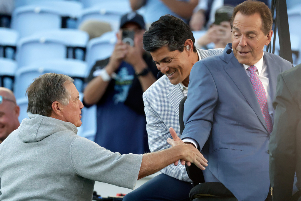 North Carolina head coach Bill Belichick, left, greets the ESPN crew before an NCAA college football game against TCU, Monday, Sept. 1, 2025, in Chapel Hill, N.C. (AP Photo/Chris Seward)