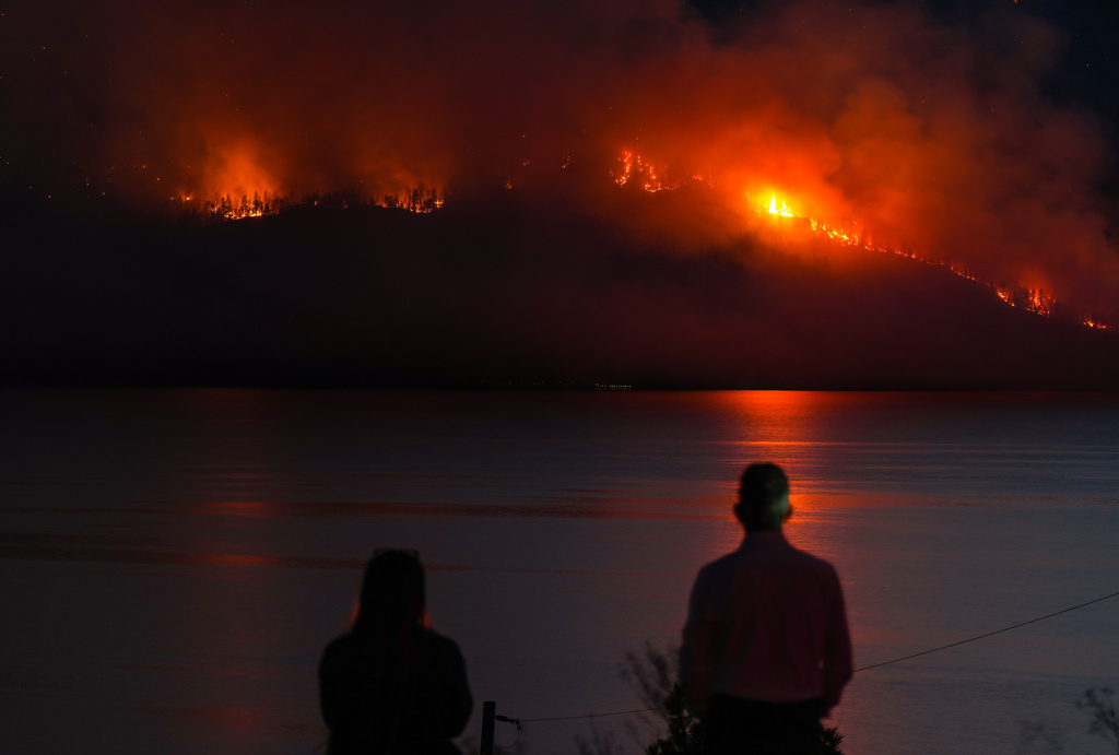 FILE - People in Lake Country, British Columbia, watch as the Quilpituk Creek wildfire burns on the mountainside across Okanagan Lake, near Fintry, Aug. 3, 2026. (Darryl Dyck/The Canadian Press via AP, File)