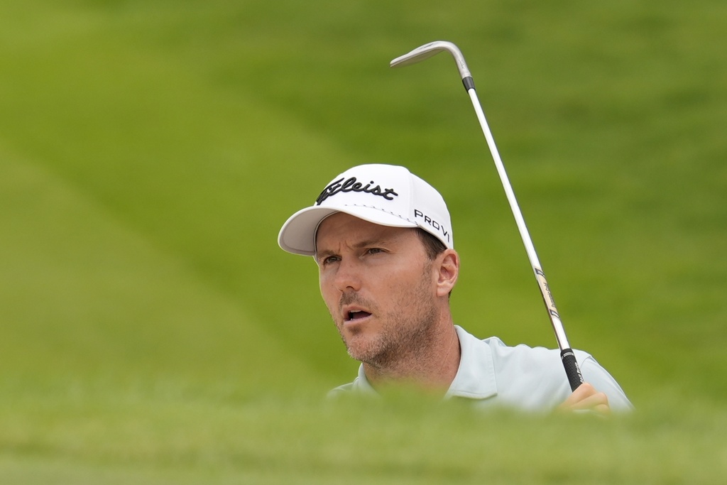 Russell Henley watches his ball out of a bunker on the 18th green during the second round of the Tour Championship golf tournament, Friday, Aug. 22, 2025, in Atlanta. (AP Photo/Mike Stewart)