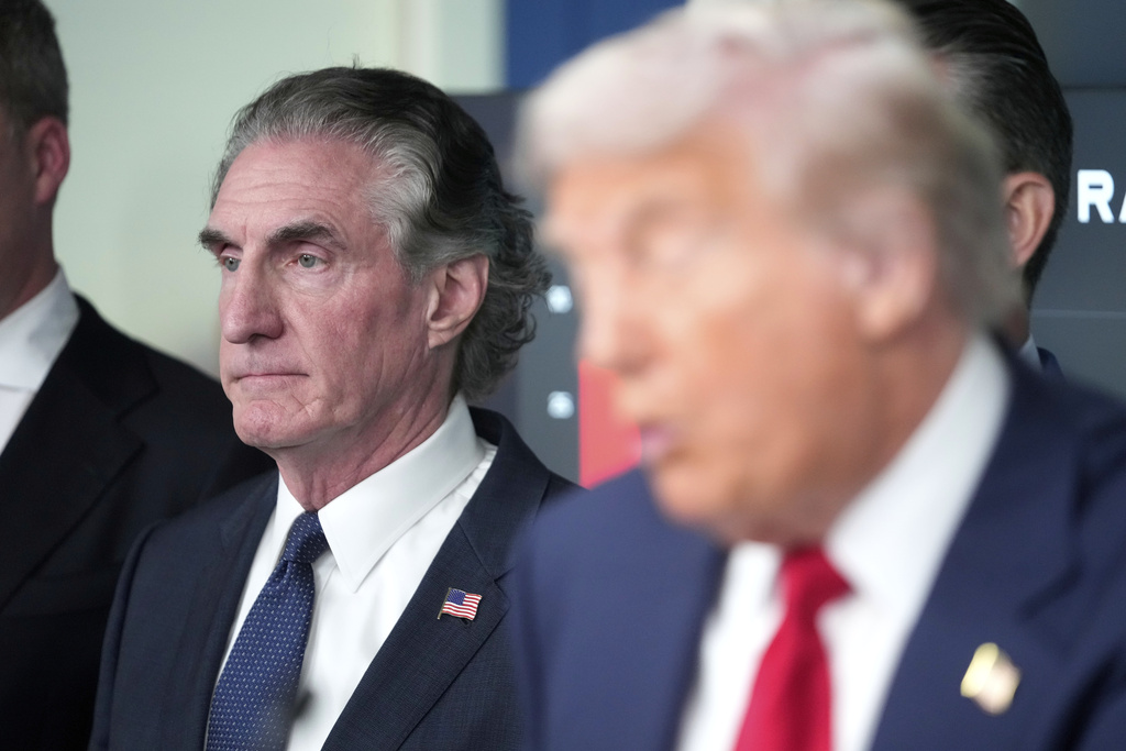 FILE - Interior Secretary Doug Burgum listens as President Donald Trump speaks with reporters in the James Brady Press Briefing Room at the White House, Monday, Aug. 11, 2025, in Washington. (AP Photo/Mark Schiefelbein, File)
