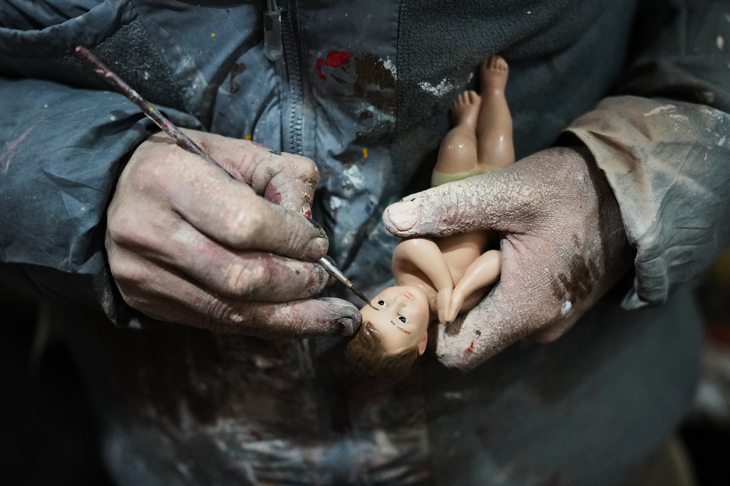 Adolfo Vertiz repairs a figurine of Baby Jesus ahead of "Día de la Candelaria," or Candlemas, in Mexico City, Thursday, Jan. 29, 2026. (AP Photo/Eduardo Verdugo)