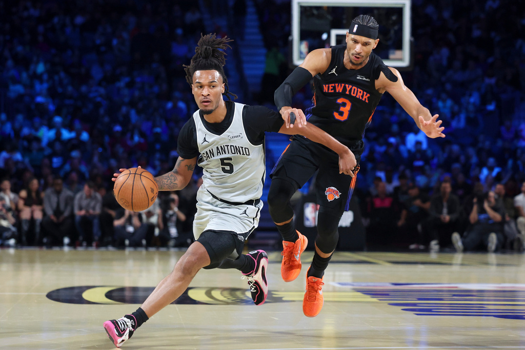 San Antonio Spurs guard Stephon Castle (5) drives against New York Knicks guard Josh Hart (3) during the first half of the NBA Cup championship basketball game Tuesday, Dec. 16, 2025, in Las Vegas. (AP Photo/Ian Maule)