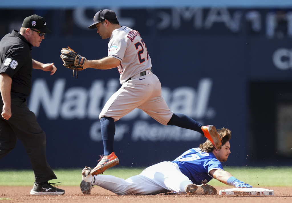 Toronto Blue Jays' Addison Barger (47) slides safely into second base past Houston Astros' Jose Altuve (27) after hitting a double during the first inning of a baseball game in Toronto, Thursday, Sept. 11, 2025. (Nathan Denette/The Canadian Press via AP)