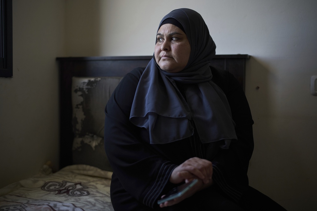 Rudeina Amouri, 42, holds a broken smartphone that belonged to her 13-year-old daughter, Rimas Amouri, who was killed during an Israeli raid while standing in the courtyard of their home, in the West Bank city of Jenin on April 21, 2025. (AP Photo/Leo Correa)
