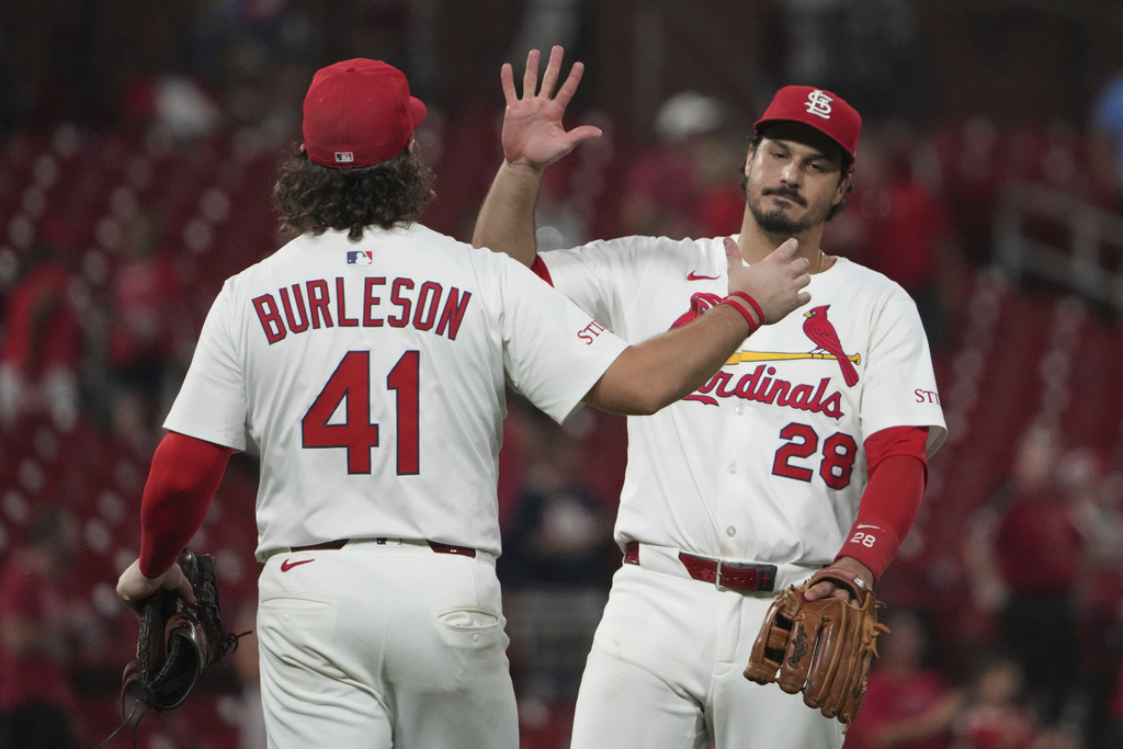 St. Louis Cardinals' Nolan Arenado (28) and Alec Burleson celebrate a victory over the Cincinnati Reds following a baseball game Tuesday, Sept. 16, 2025, in St. Louis. (AP Photo/Jeff Roberson)