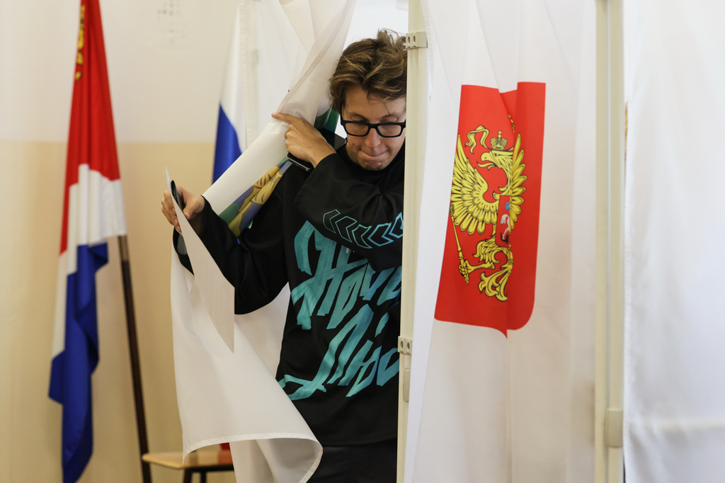 A woman leaves a voting booth to cast her ballot in the parliamentary election in Vladivostok, Russia, Friday, Sept. 18, 2026. (AP Photo)