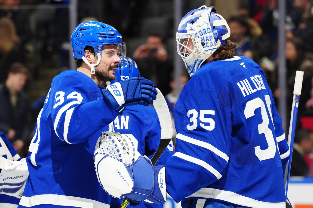 Toronto Maple Leafs' Auston Matthews (34) and goaltender Dennis Hildeby (35) celebrate after defeating the Winnipeg Jets in an NHL hockey game in Toronto, Thursday, Jan. 1, 2026. (Frank Gunn/The Canadian Press via AP)