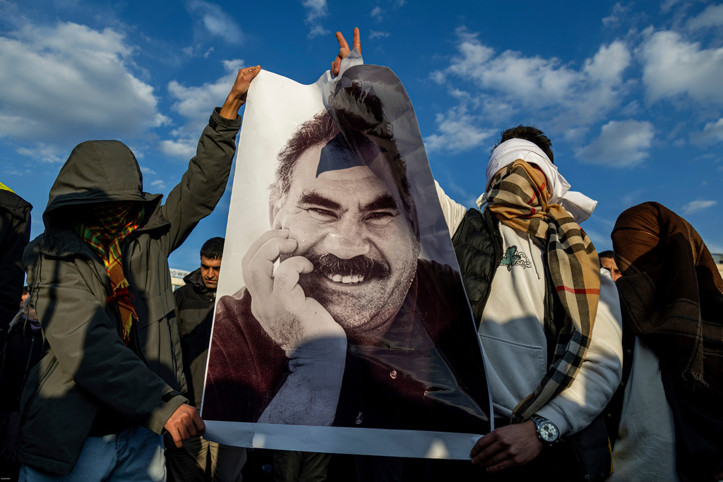 FILE - Youngsters hold a photograph of Abdullah Ocalan, the jailed leader of the militant Kurdish group, or PKK, in Diyarbakir, Turkey, Feb. 27, 2025. (AP Photo/Metin Yoksu, File)