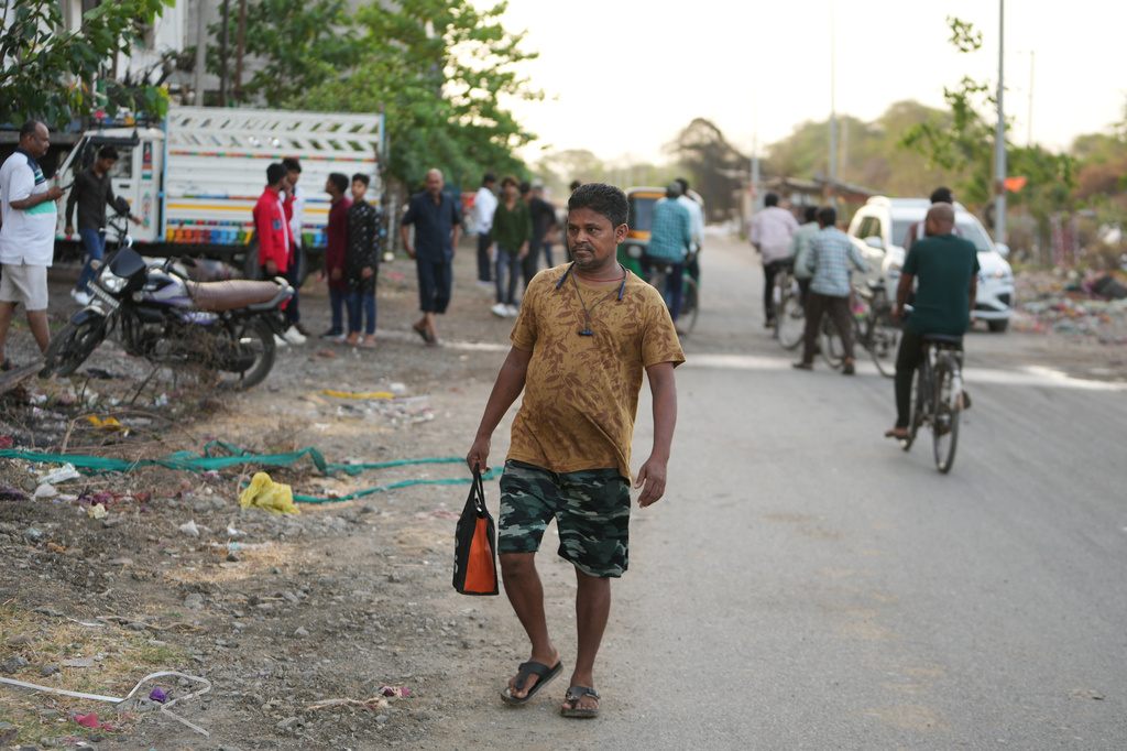 Power loom factory worker Sibaram Pradhan walks to work from his residential quarters in Surat, India, Thursday, May 28, 2026. (AP Photo/Ajit Solanki)