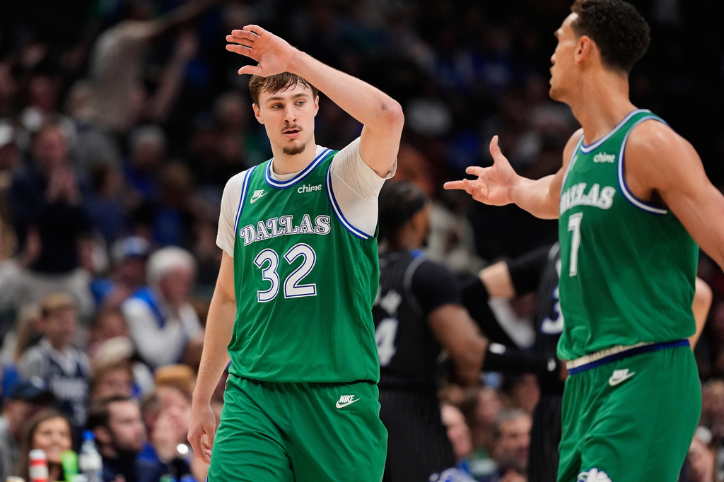 Dallas Mavericks forward Cooper Flagg (32) and Dwight Powell, right, celebrate a basket by Flagg in the second half of an NBA basketball game against the Orlando Magic Friday, April 3, 2026, in Dallas. (AP Photo/Tony Gutierrez)