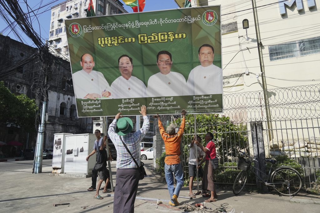 Members of the military-backed Union Solidarity and Development Party (USDP) remove a campaign poster during the last day of the first phase of an election campaign in Yangon, Myanmar, Friday, Dec. 26, 2025. (AP Photo/Thein Zaw)